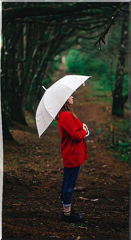 Woman in forest with umbrella